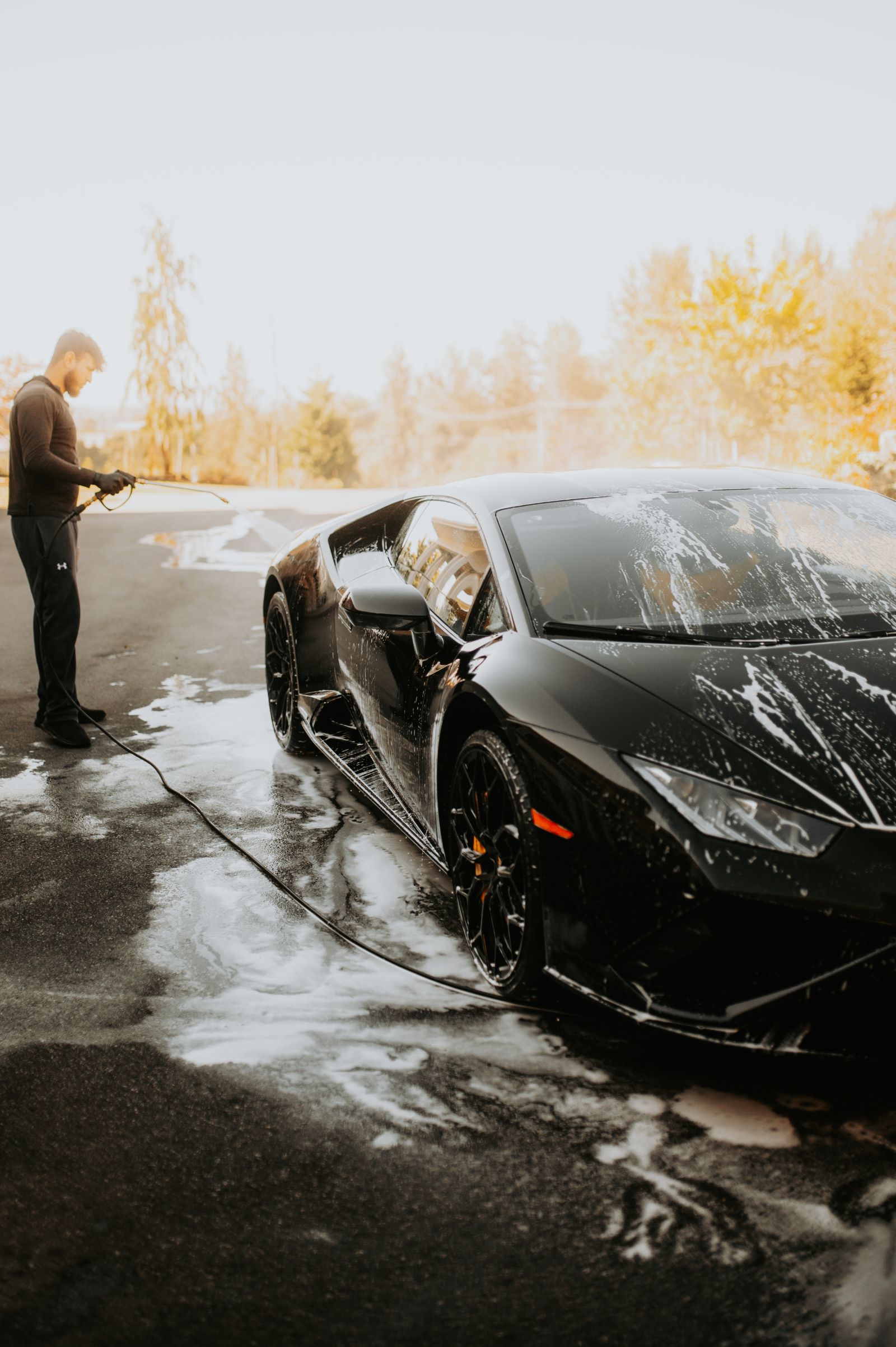 Illustrative stock photo of a dark car being washed by hand