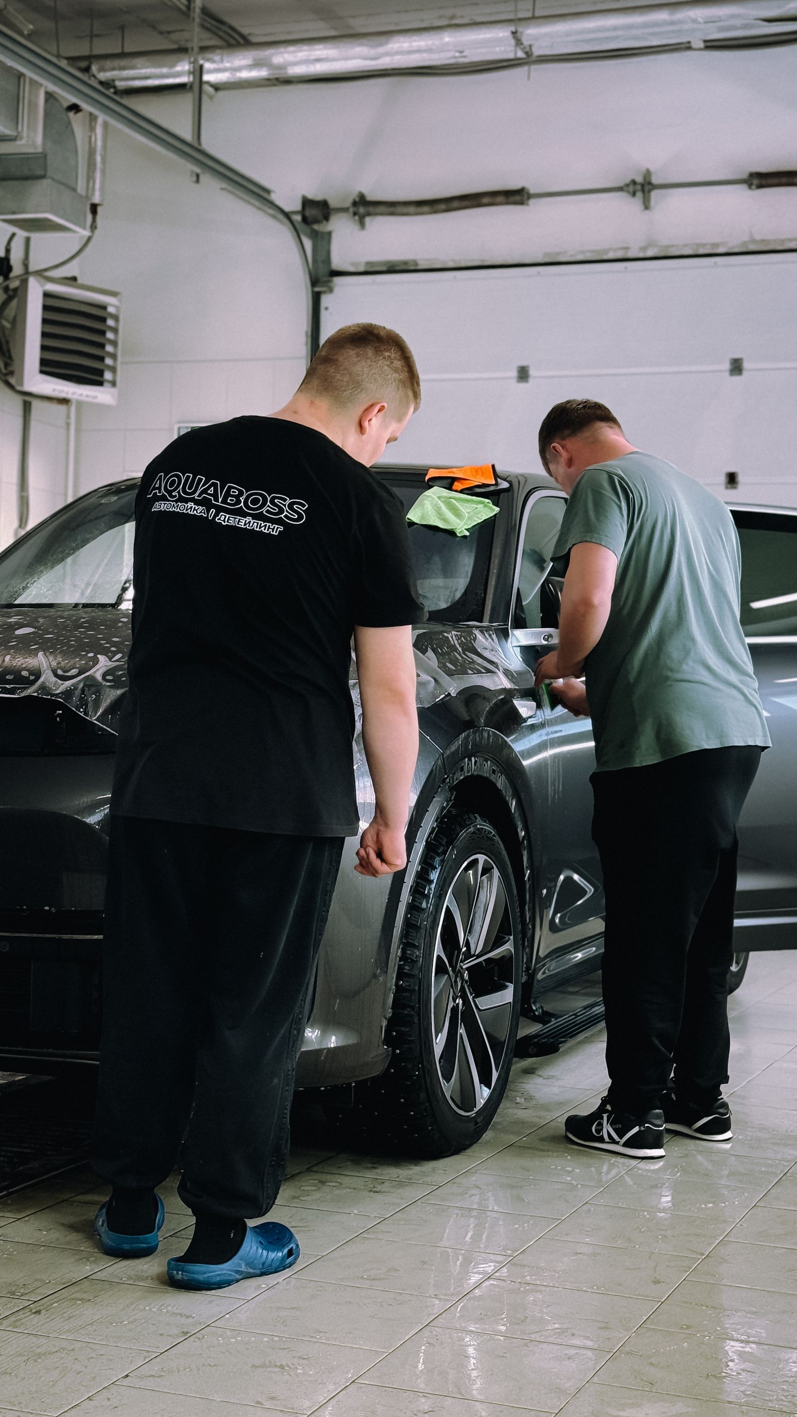 Detailing professionals cleaning a vehicle in a workshop